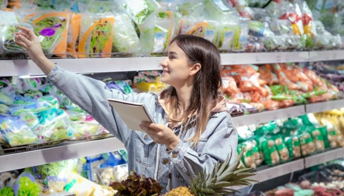 young-woman-with-notebook-buys-groceries-supermarket